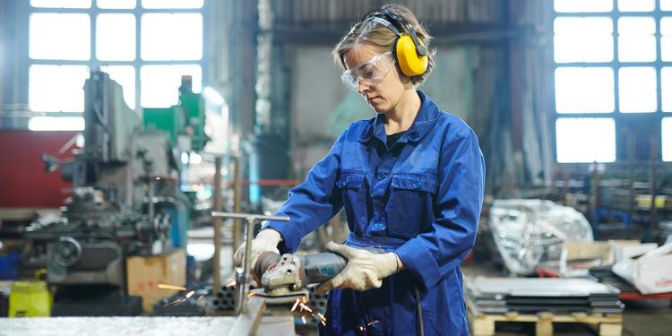 Una mujer trabaja en un taller de carpintería metálica